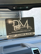 Load image into Gallery viewer, A photo of the all-new Phaser Black Ice air freshener in a truck