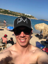 Load image into Gallery viewer, Clay Reierson wearing our PM hat on a trip to Greece
